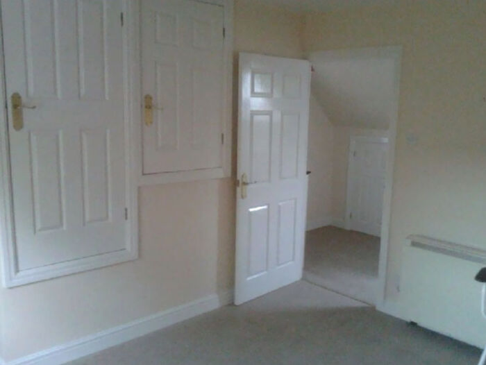 A small room with multiple doors, one leading to another cramped space, from unhinged real estate listings.