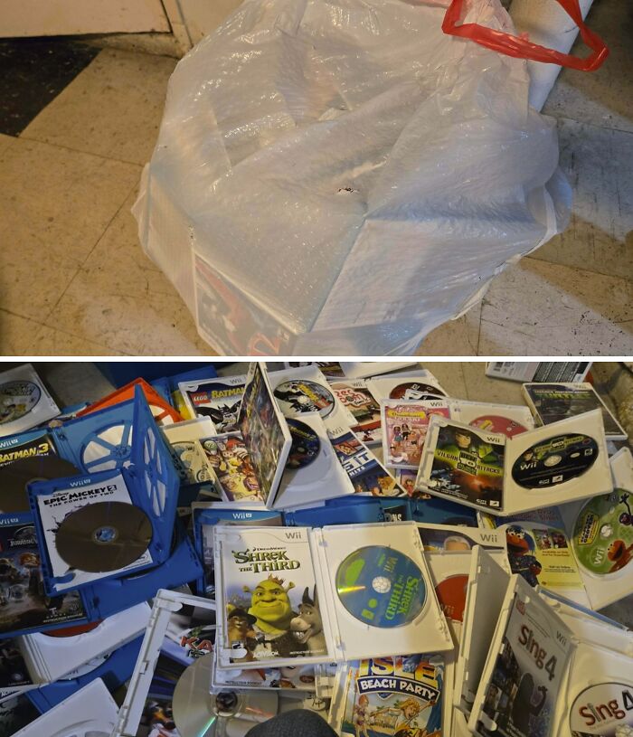 A clear bag full of Wii games sits on a floor, with more games scattered nearby, found while dumpster diving.