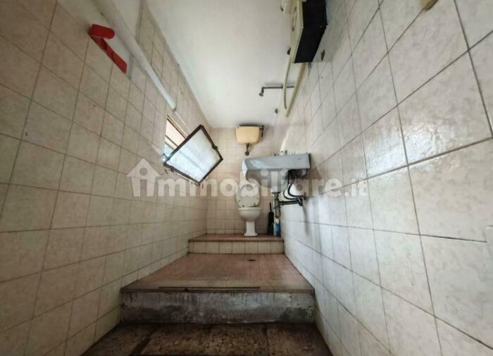 Unhinged real estate listings depicting a small, tiled bathroom with a toilet and sink elevated on a platform, requiring a trigger warning.