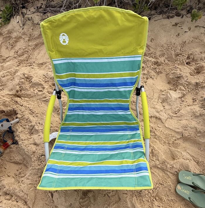 Prime Day outdoor essentials: A striped green and blue beach chair on sand, ready for summer ease and relaxation.