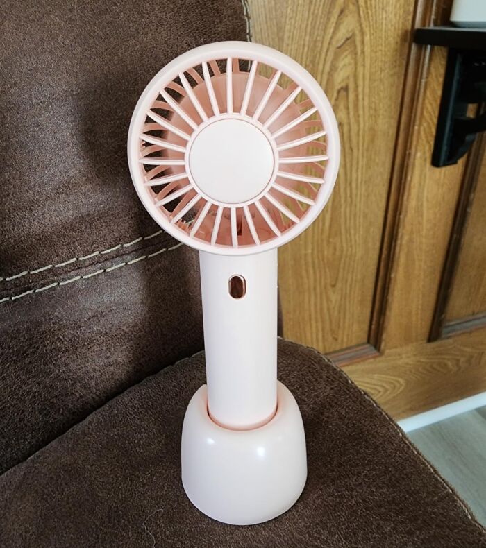 Prime Day outdoor essentials: A pink portable handheld fan, perfect for keeping cool with ease during the summer.