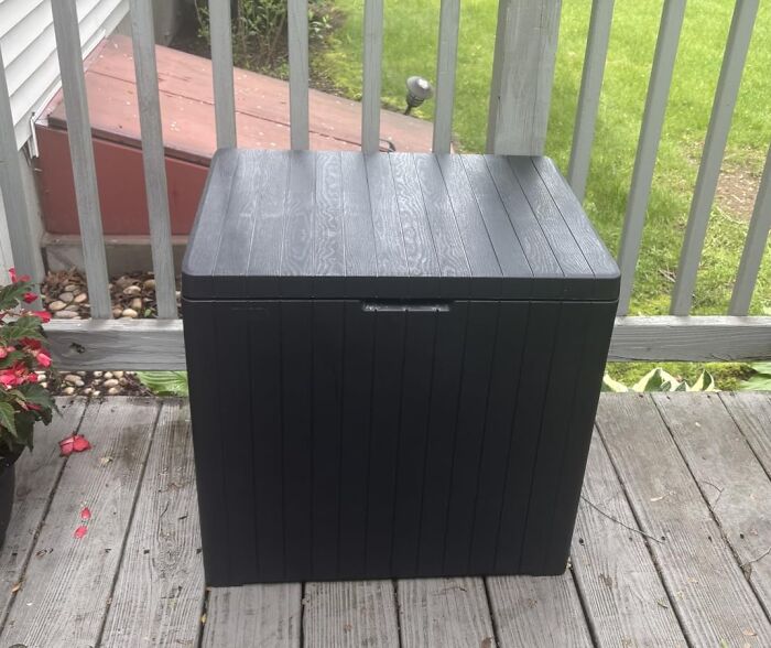 Prime Day outdoor essentials: A dark outdoor storage box on a wooden deck, useful for summer backyard essentials.
