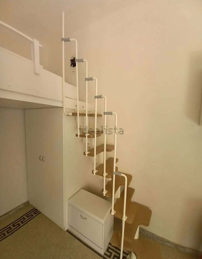 A steep, zigzagging ladder-style staircase leading to a loft, an unhinged real estate listing feature.