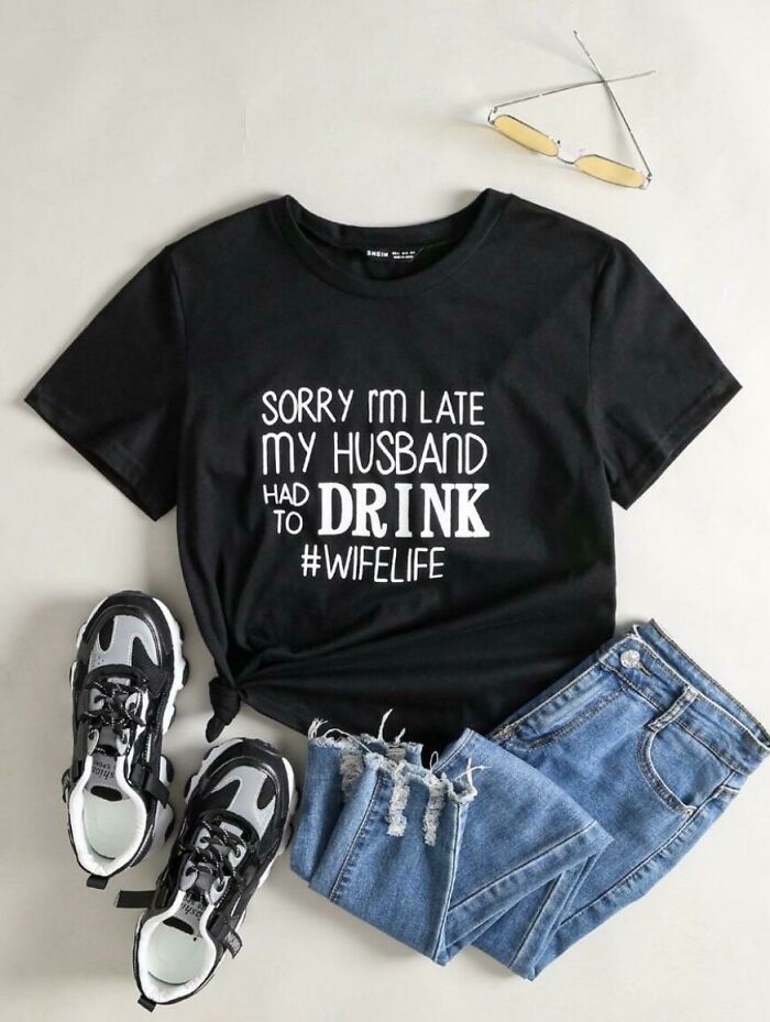 A black t-shirt with the text Sorry I'm late my husband had to drink #wifelife, paired with jeans and sneakers.