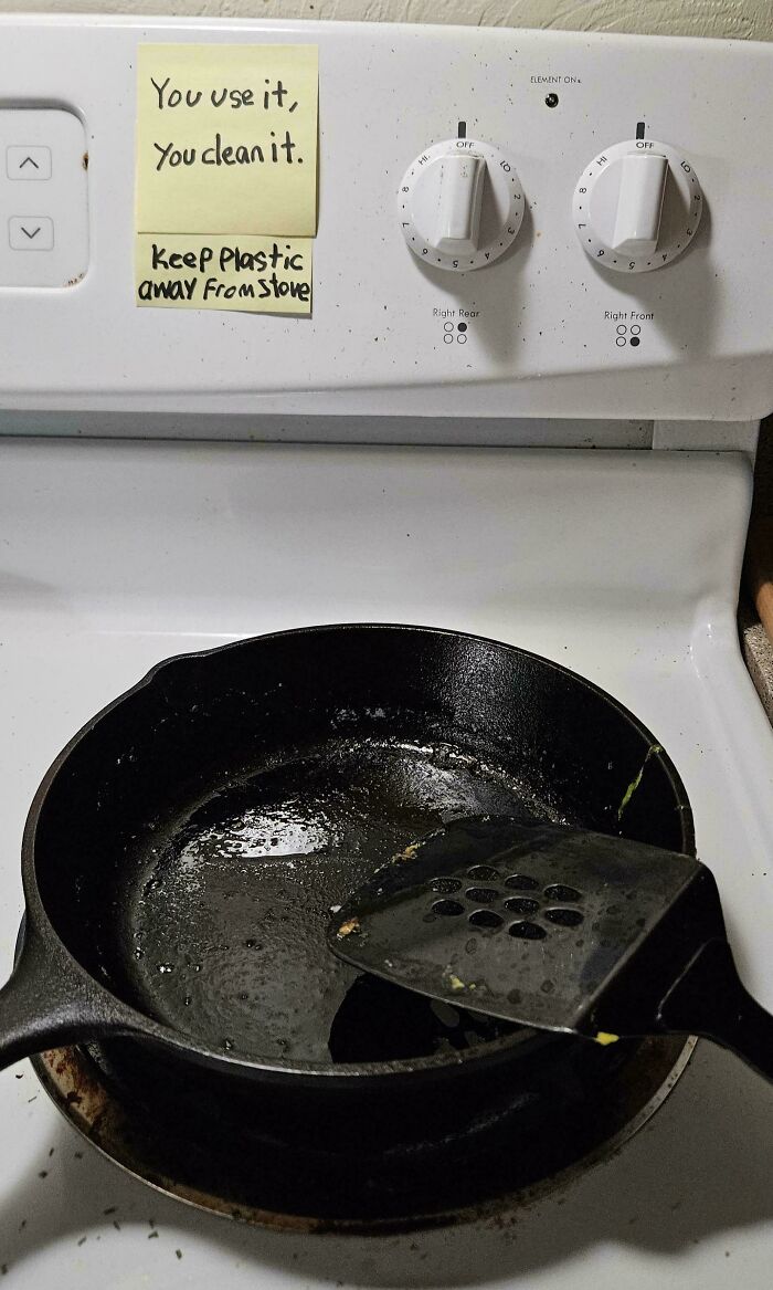 A dirty frying pan left on a stove with a note, highlighting issues with horrible roommates.