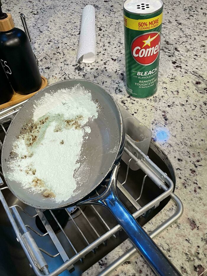 A dirty frying pan covered in white cleaning powder next to a can of Comet bleach, left by a horrible roommate.