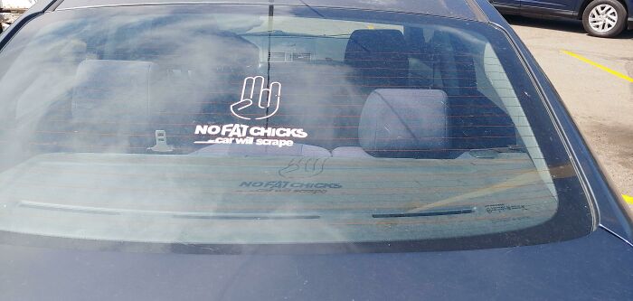 A car with a sticker that reads No Fat Chicks... car will scrape, highlighting toxic masculinity.
