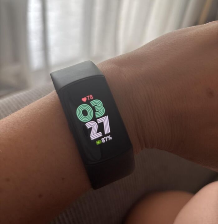 A fitness tracker displaying the date and heart rate on a wrist, representing Prime Day electronics deals.