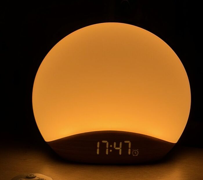 A modern sunrise alarm clock glowing warmly, a top Prime Day electronics deal to step up your tech game.