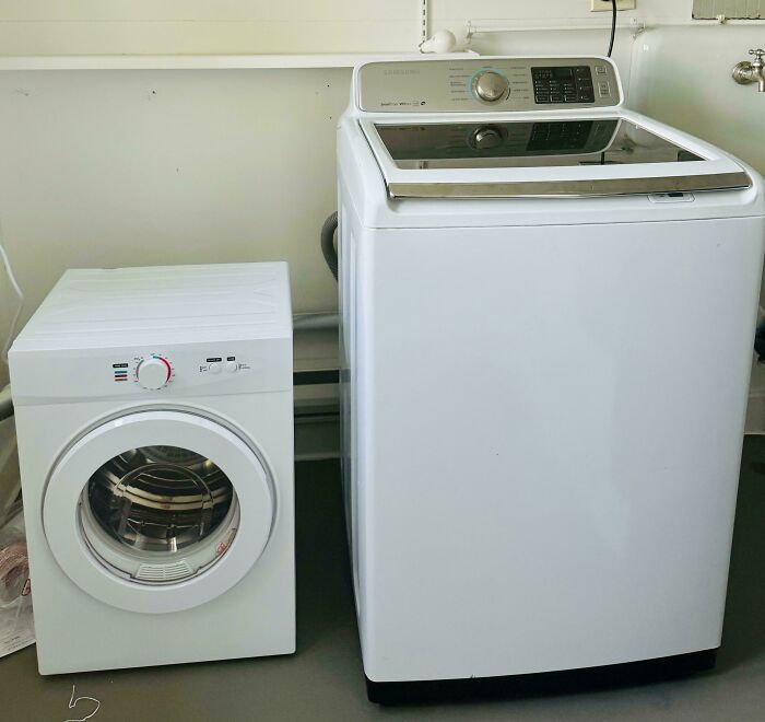 A tiny, inadequate dryer next to a full-sized washing machine, highlighting a landlord's unreasonable choices.