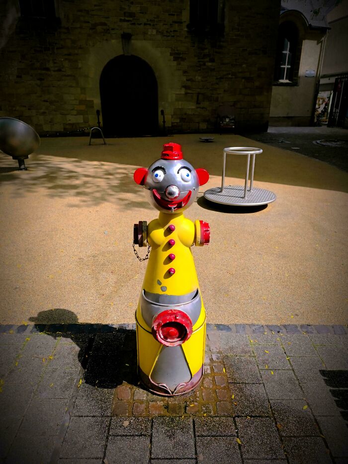 A yellow and red fire hydrant shaped like a clown, one of many creepy design fails.