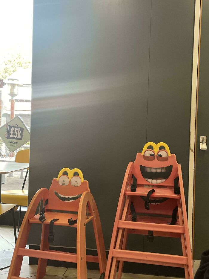 Two McDonald's high chairs with creepy smiling faces, creating an uncomfortable design fail.