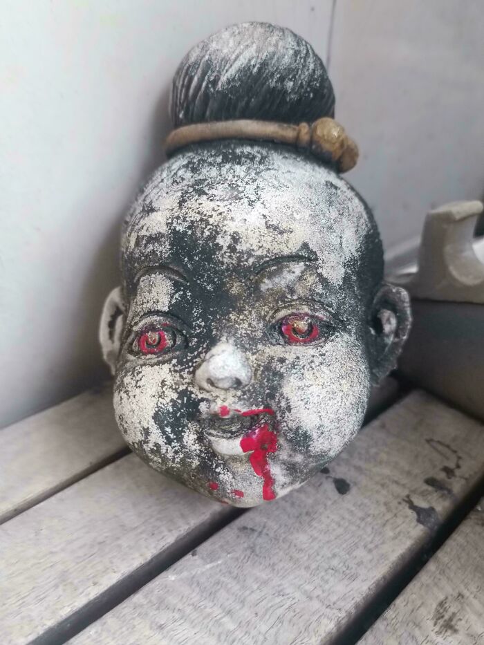 Creepy design fail: a doll head with red eyes and blood-like paint, making people feel uncomfortable.