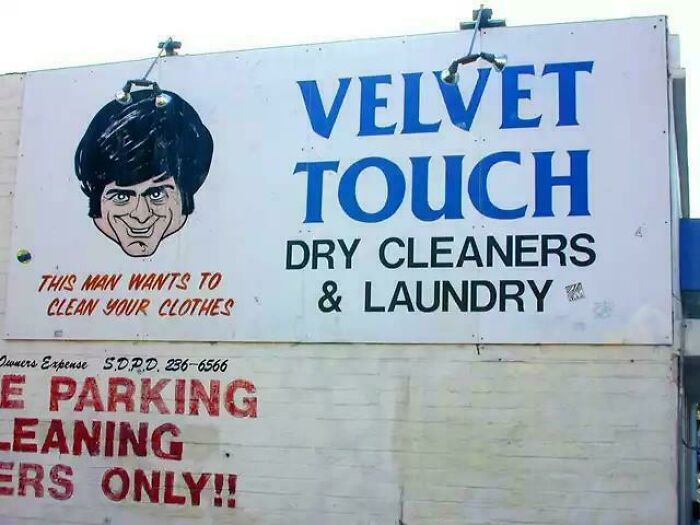 Creepy design fail: a billboard for Velvet Touch Dry Cleaners with an unsettling cartoon man.
