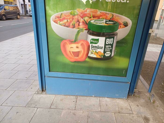 Creepy design fail: a bell pepper with a smiling face on a Knorr advertisement at a bus stop.