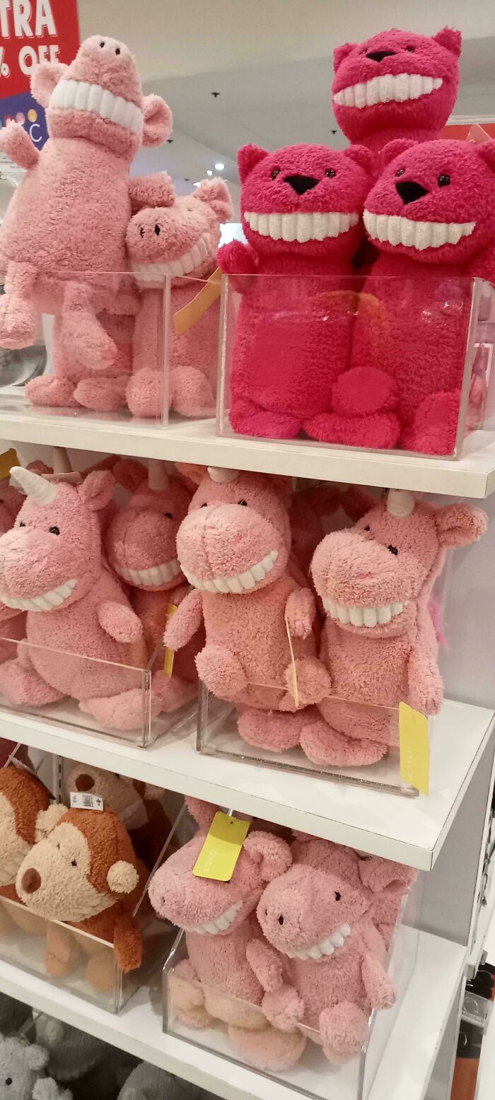 Several pink stuffed animals with unsettlingly large, human-like teeth on display, a creepy design fail.
