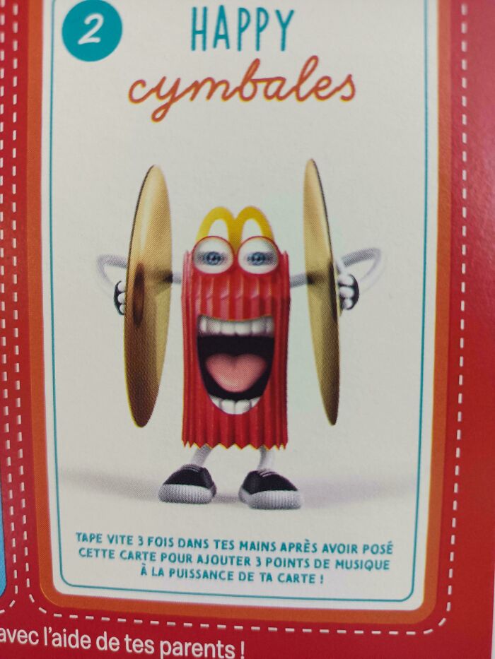 A McDonald's Happy Meal box character with wide eyes and a gaping mouth playing cymbals, a creepy design fail.