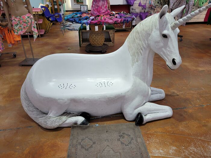 A creepy, white unicorn-shaped bench with a strange, uncomfortable seat, a design fail.