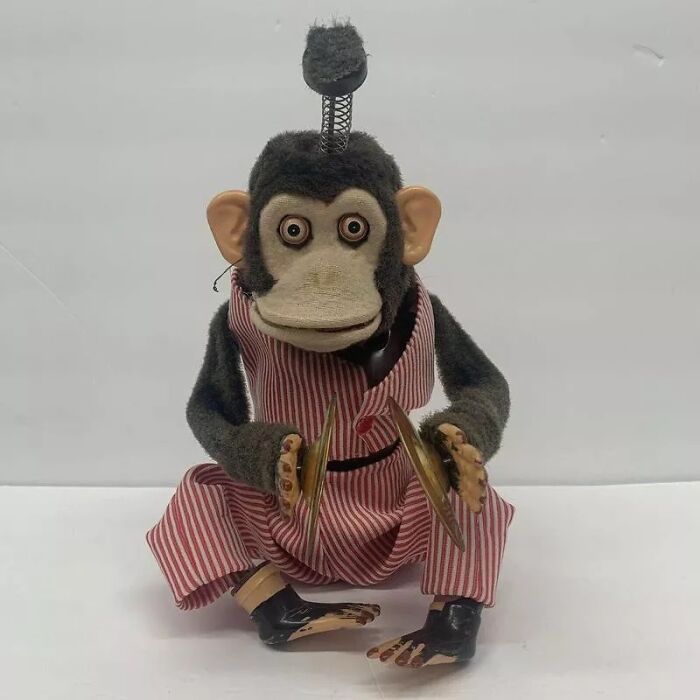A vintage cymbal-banging monkey toy, an uncomfortable design fail with a creepy stare.