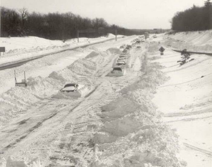 Cars stuck in deep snow on a highway, depicting a historical event that could be an unsolved mystery.