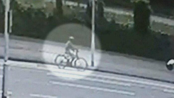 Grainy surveillance footage of a person on a bicycle, a common element in unsolved mysteries.