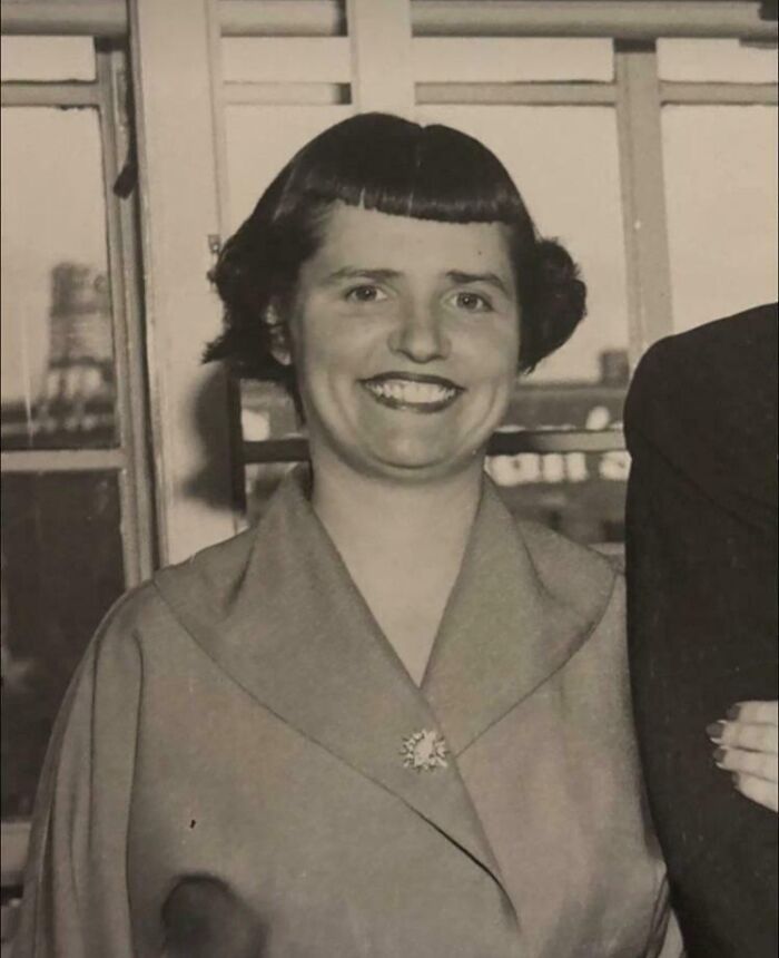 A smiling woman with an unfortunate short bob haircut and very short bangs.