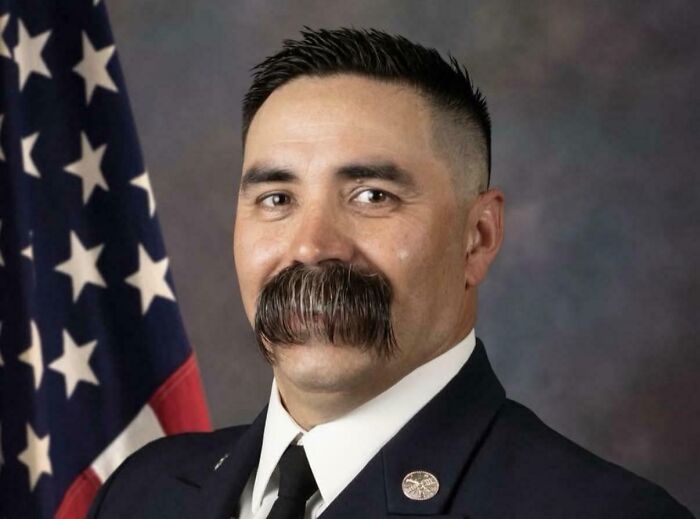 Man with an unfortunate haircut, featuring a high fade and a very large mustache.