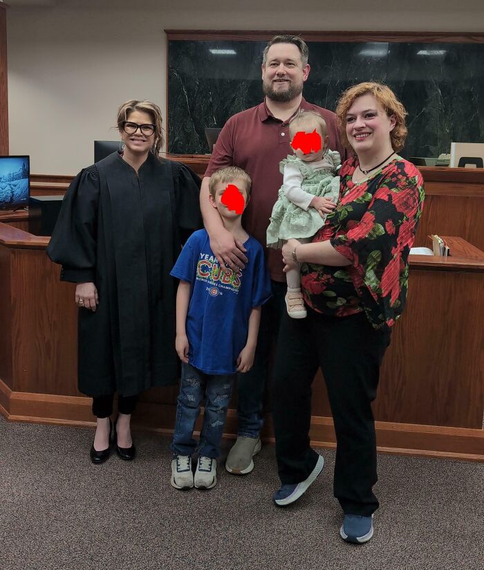 Family and judge celebrating a successful adoption, highlighting a joyous adoption story.