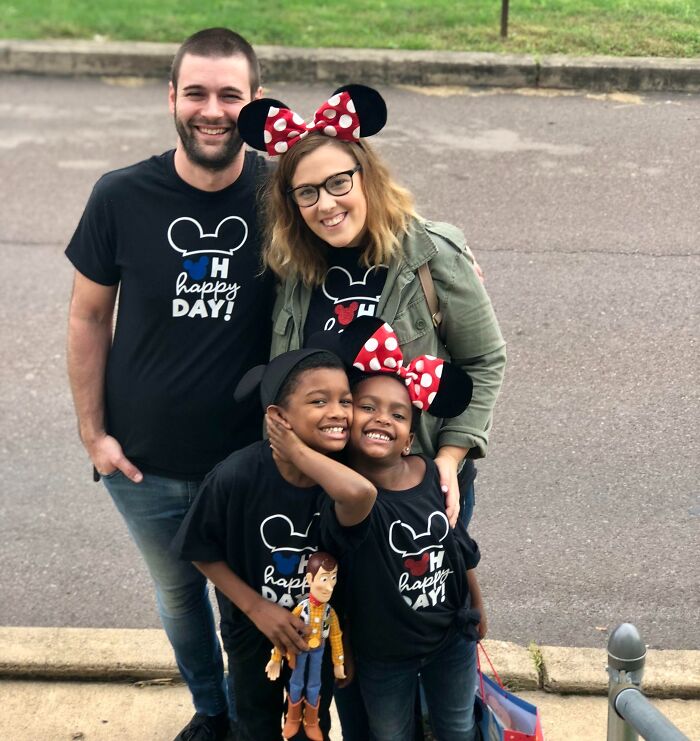 An adoptive family of four in matching shirts and Minnie Mouse ears, celebrating their adoption stories.