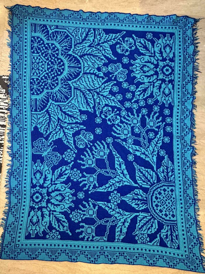An incredible blue crochet blanket with light blue floral and geometric patterns, shared by enthusiasts.