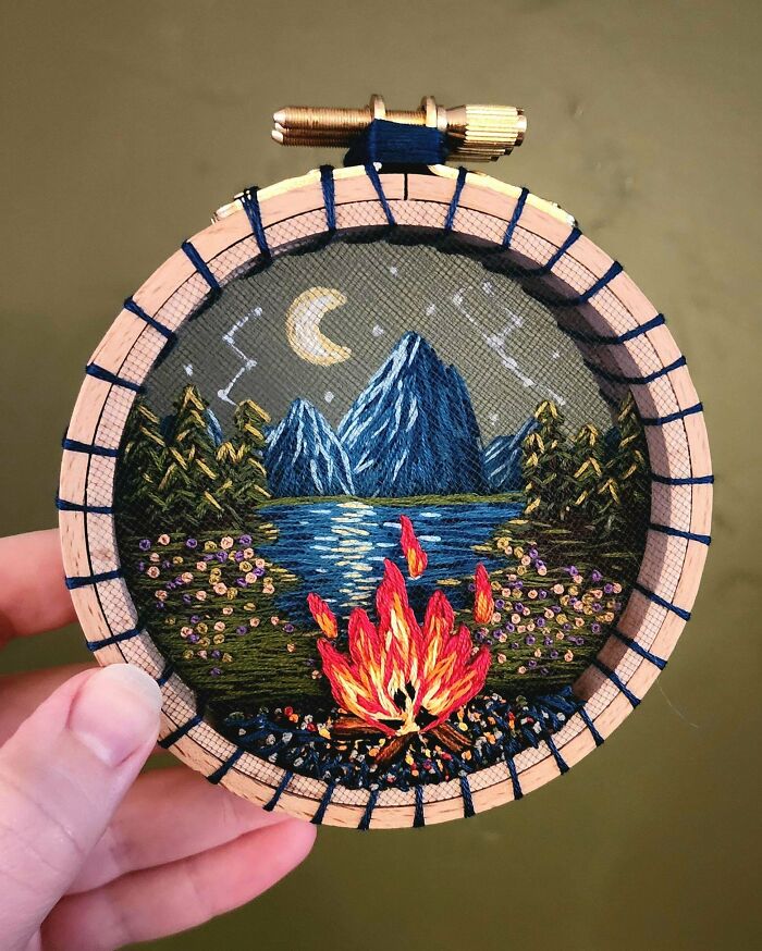 Handmade embroidery projects of a campfire scene at night under a crescent moon.