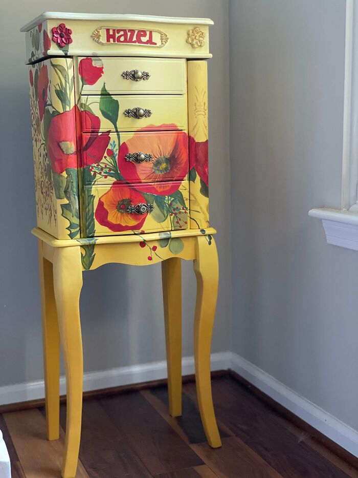 A small, elegant piece of furniture with a vibrant floral design, showcasing its revived potential.
