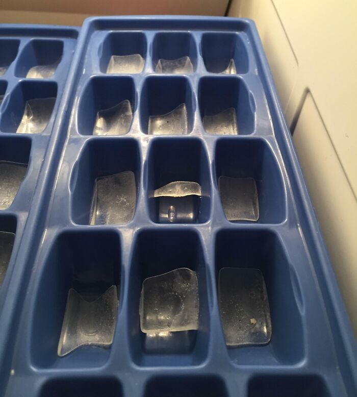A blue ice tray with only a few small, broken ice pieces left, showing the habits of horrible roommates.