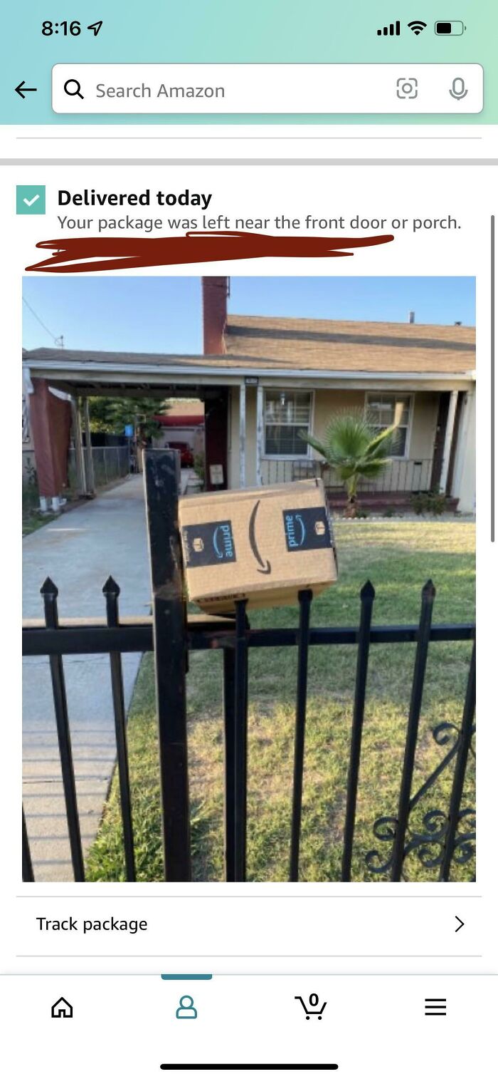An Amazon tracking screenshot showing a package precariously balanced on a metal fence in front of a house, demonstrating delivery fails.