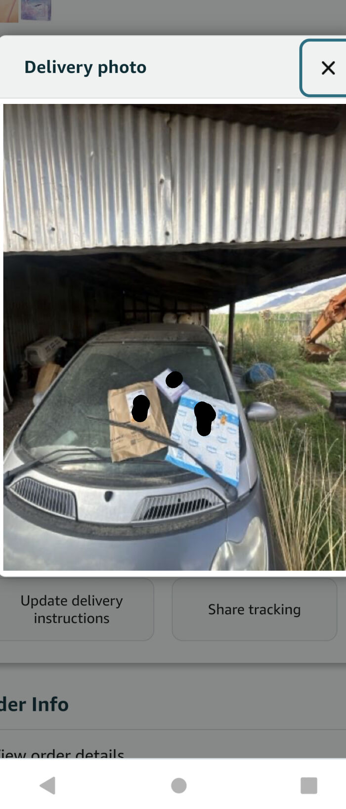 Several packages are haphazardly placed on the windshield of a small car, showcasing a delivery fail.