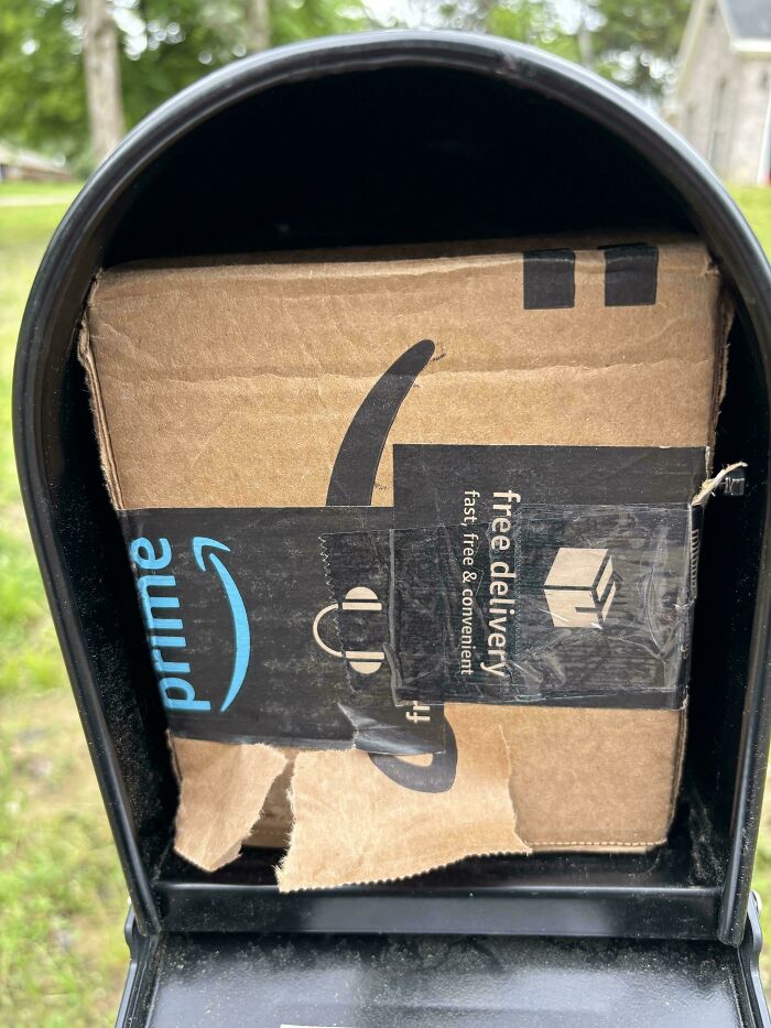 An oversized Amazon package crammed into a small mailbox, highlighting a common delivery fail.