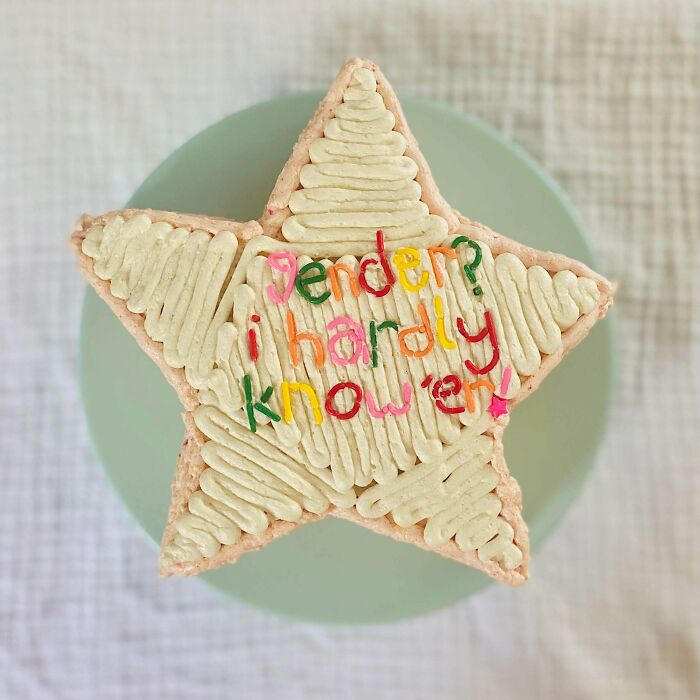 A star-shaped baker's treat cake with colorful icing that reads 'Gender? I hardly know 'em!'
