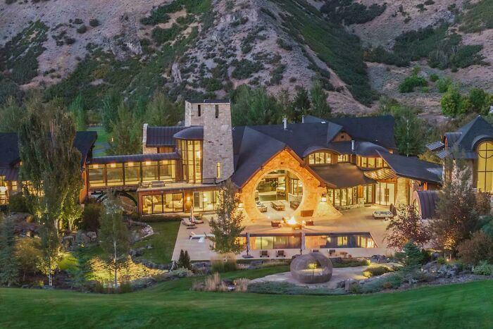 An expansive, cool home nestled in a scenic mountain valley, featuring a distinctive circular entrance and a pool. This unusual home is a modern masterpiece.