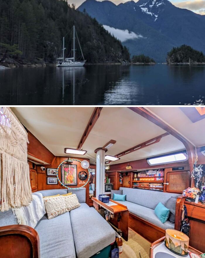 An unusual home, a sailboat anchored in a serene bay surrounded by mountains, featuring a cozy and well-decorated interior living space.