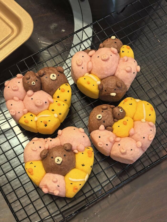 Four heart-shaped baked treats featuring small pig, bear, and chick designs, a display of amazing baking.