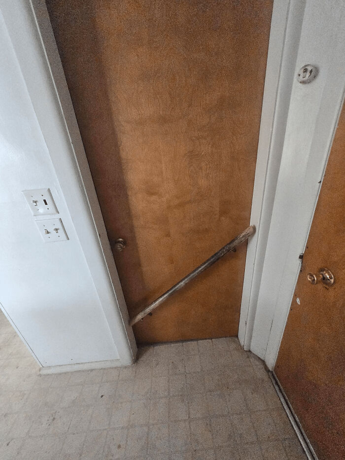 A wooden stick wedged between two doors, a clever solution to hold one door open or closed.