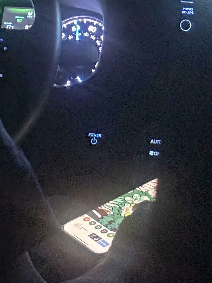 A smartphone screen reflecting on a car dashboard while driving, highlighting a lapse in basic human decency.