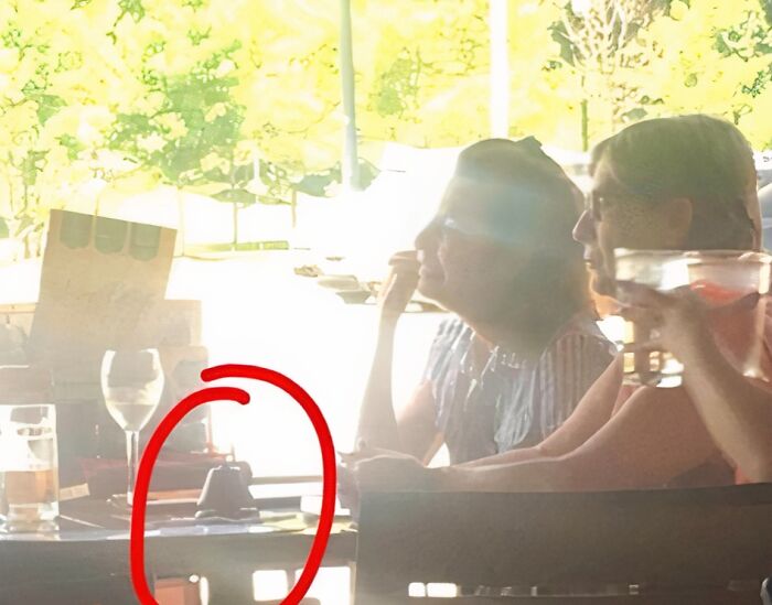 Two women at a table with a small, unidentifiable object circled in red, questioning basic human decency.
