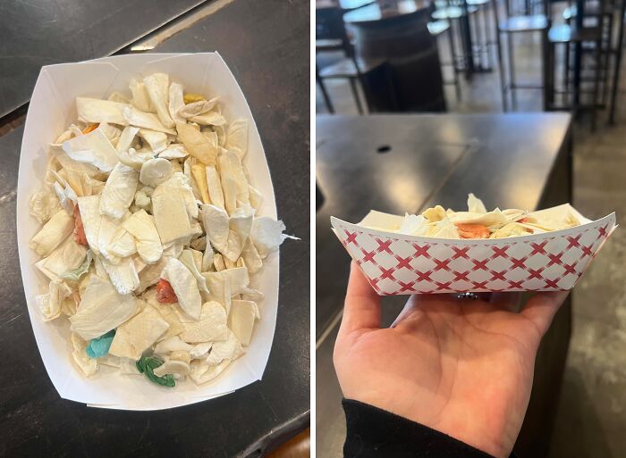A small serving of stale-looking, pale food scraps in a paper tray, highlighting a lack of basic human decency in food service.
