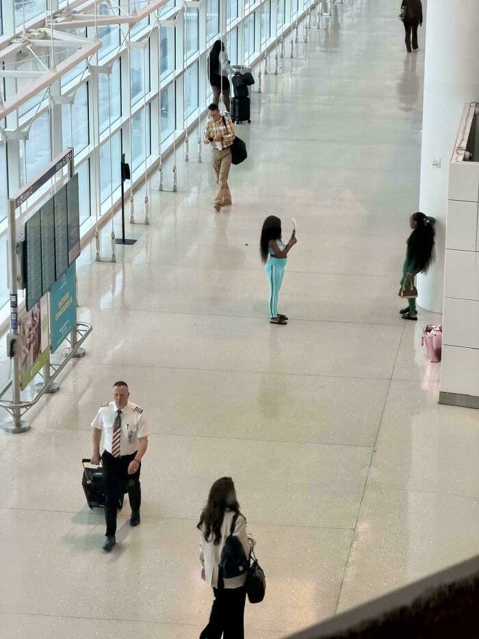 A high-angle shot of an airport terminal with people walking, highlighting a lack of basic human decency.