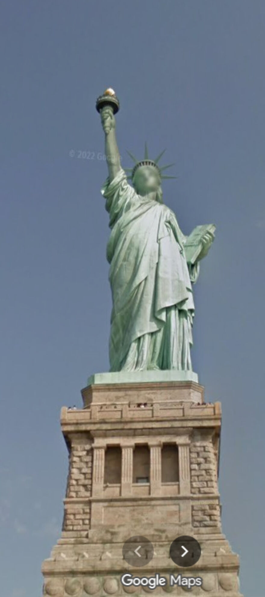 The iconic Statue of Liberty captured in a funny Google Street View photo against a clear sky.