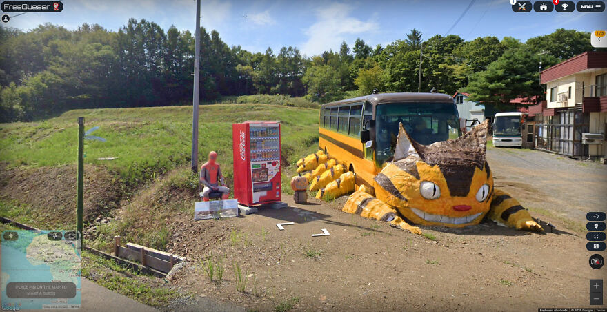 A bizarre Google Street View photo showing a Spiderman figure next to a Coca-Cola machine and a giant Totoro.