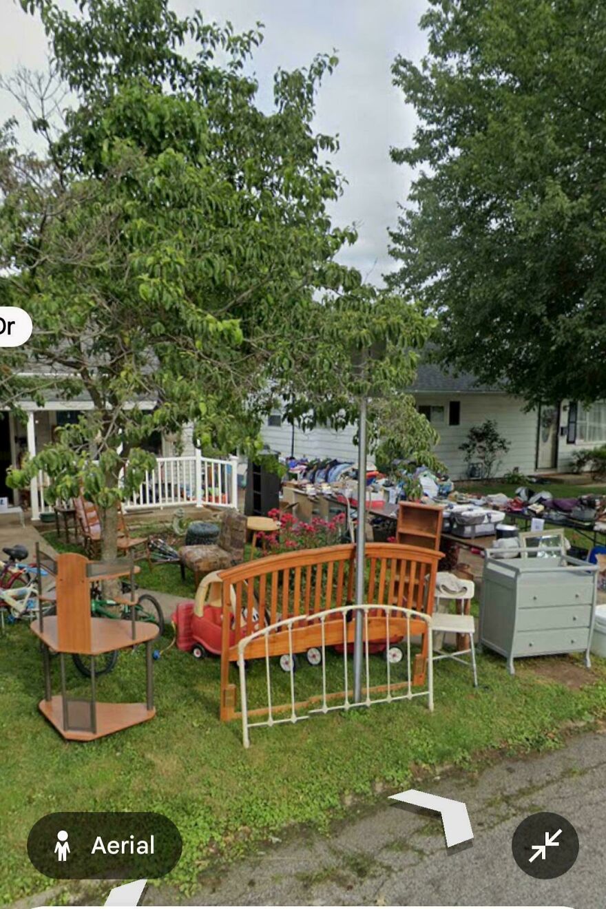 A yard sale with various items on a lawn, captured in a funny Google Street View image.