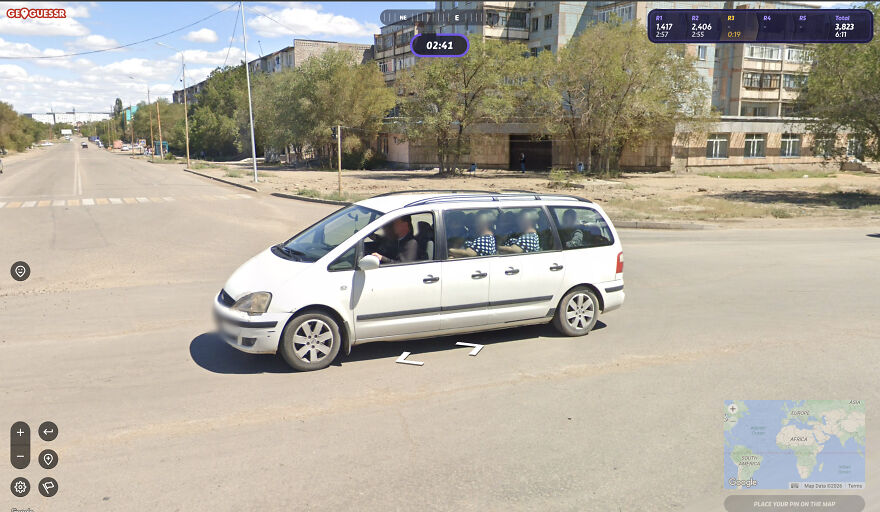 A white car driving down a street, captured in a funny Google Street View photo.