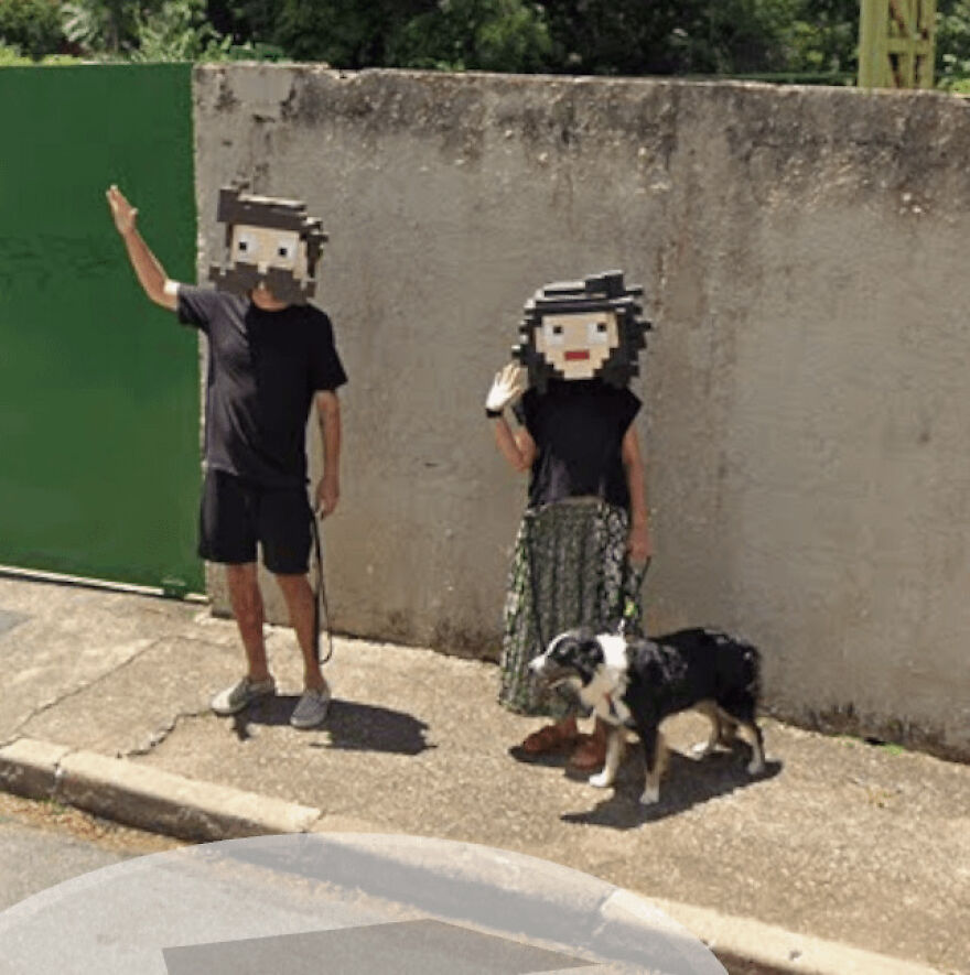Two people wearing pixelated masks and a dog, waving at the camera in a funny Google Street View photo, highlighting bizarre encounters.